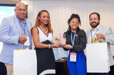 Keyana Warner is congratulated by Dona Regis-Prosper, Secretary-General & CEO of CTO, while Emile Hamilton of Tropical Shipping (left) and Ed Limon of Winged Whale Media look on.