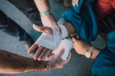 Person Applying Bandage on Another Person's Hand 